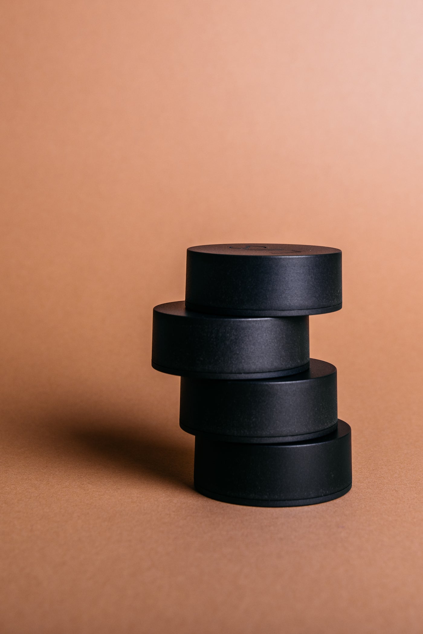 A stack of LYS Buttons on a terracotta background